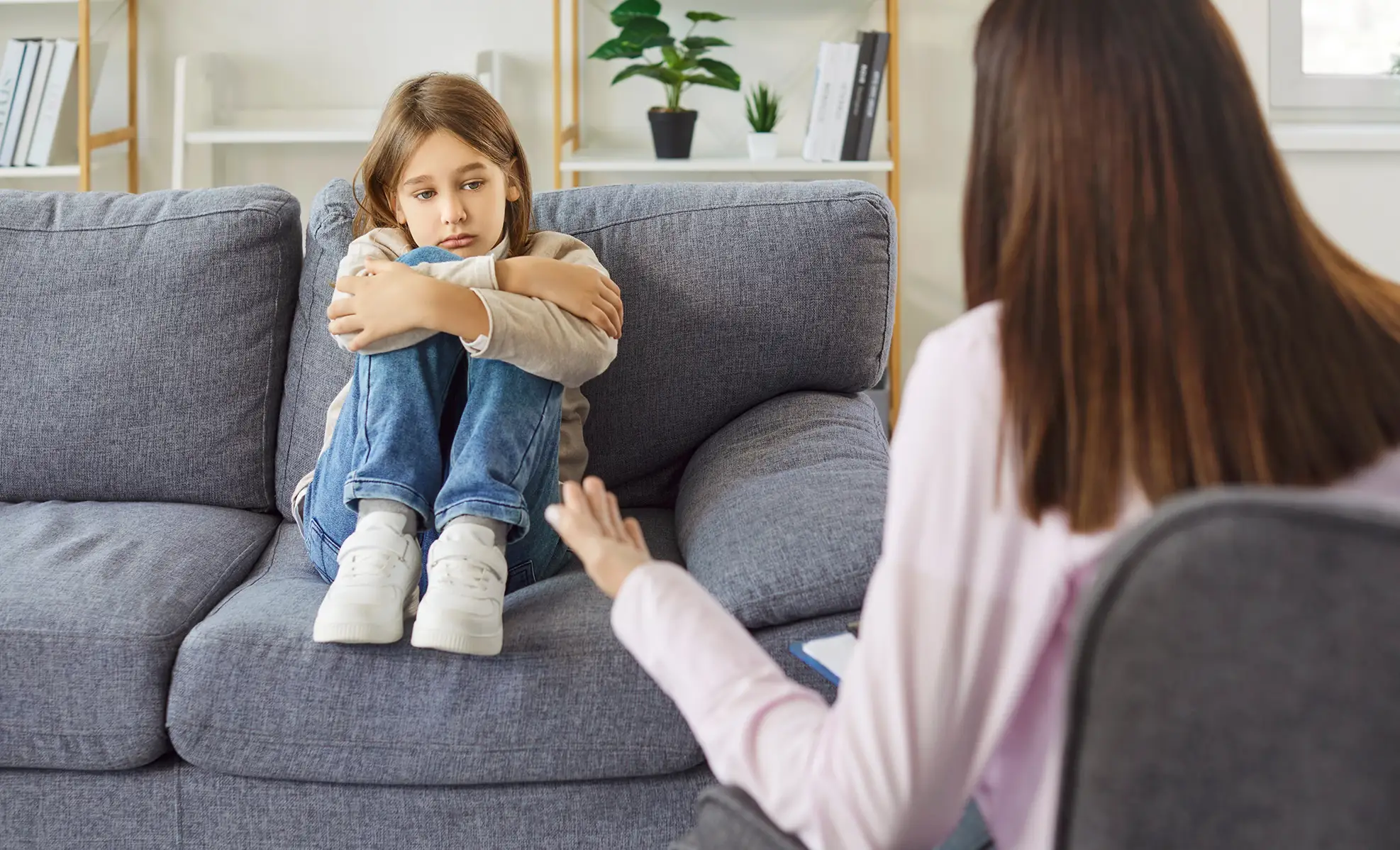 stressed child with a pediatric mental health professional in an office