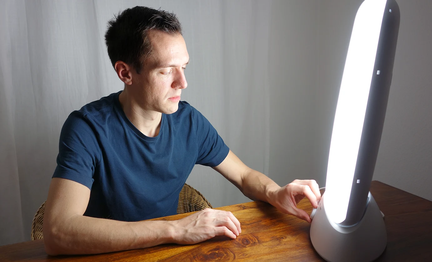 man using a light therapy lamp