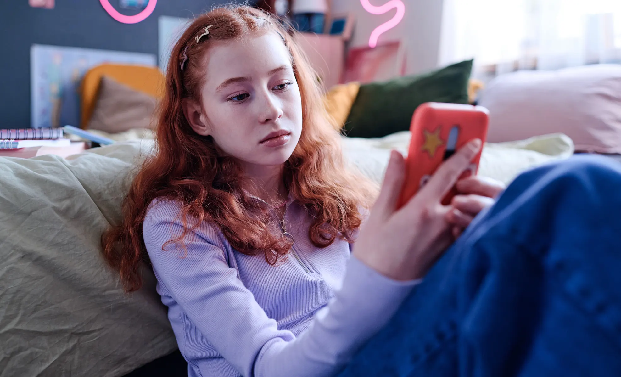 teen girl on her phone viewing social media with concerned look