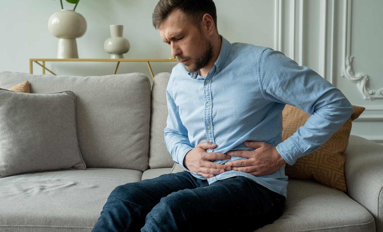 Man leaning over  holding his gut in pain