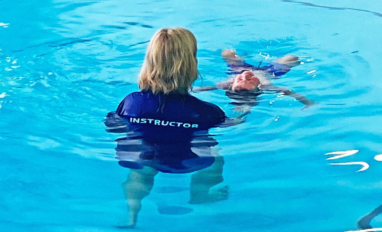 Swimming instructor with child