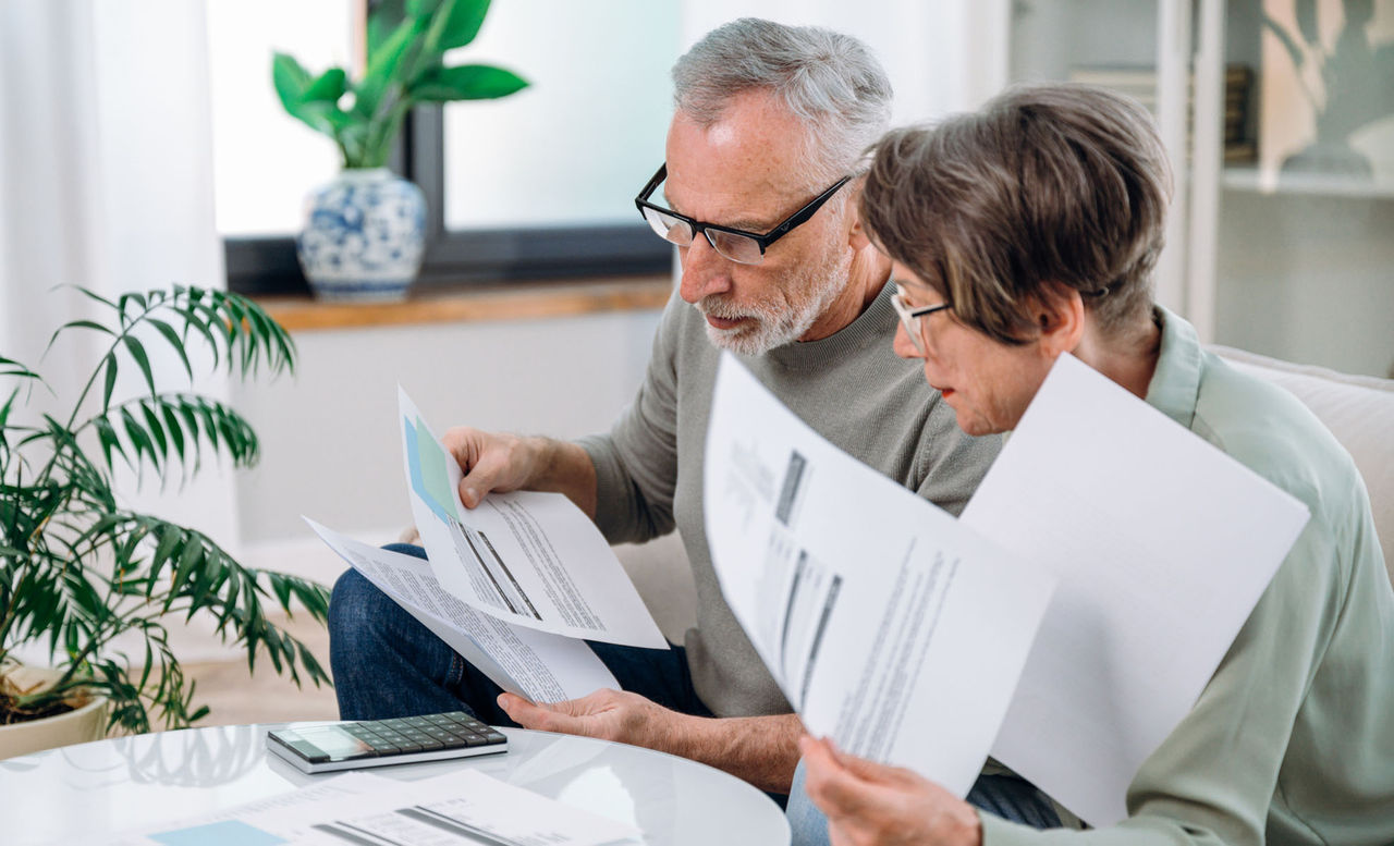 Senior couple looking over paperwork during open enrollment