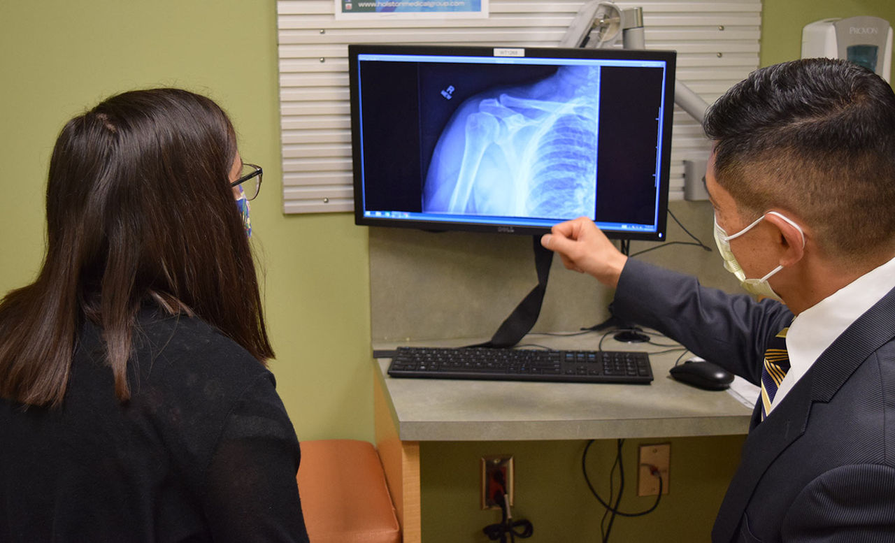 Dr. Park looking at an xray with a patient