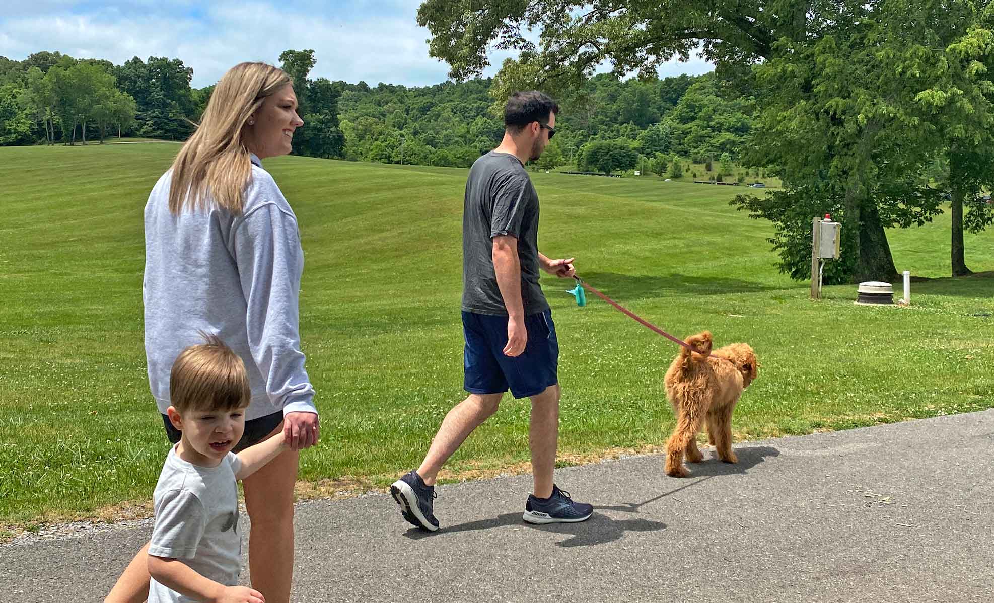 Dr. Metzger and family taking their dog Ivy for a walk in a park