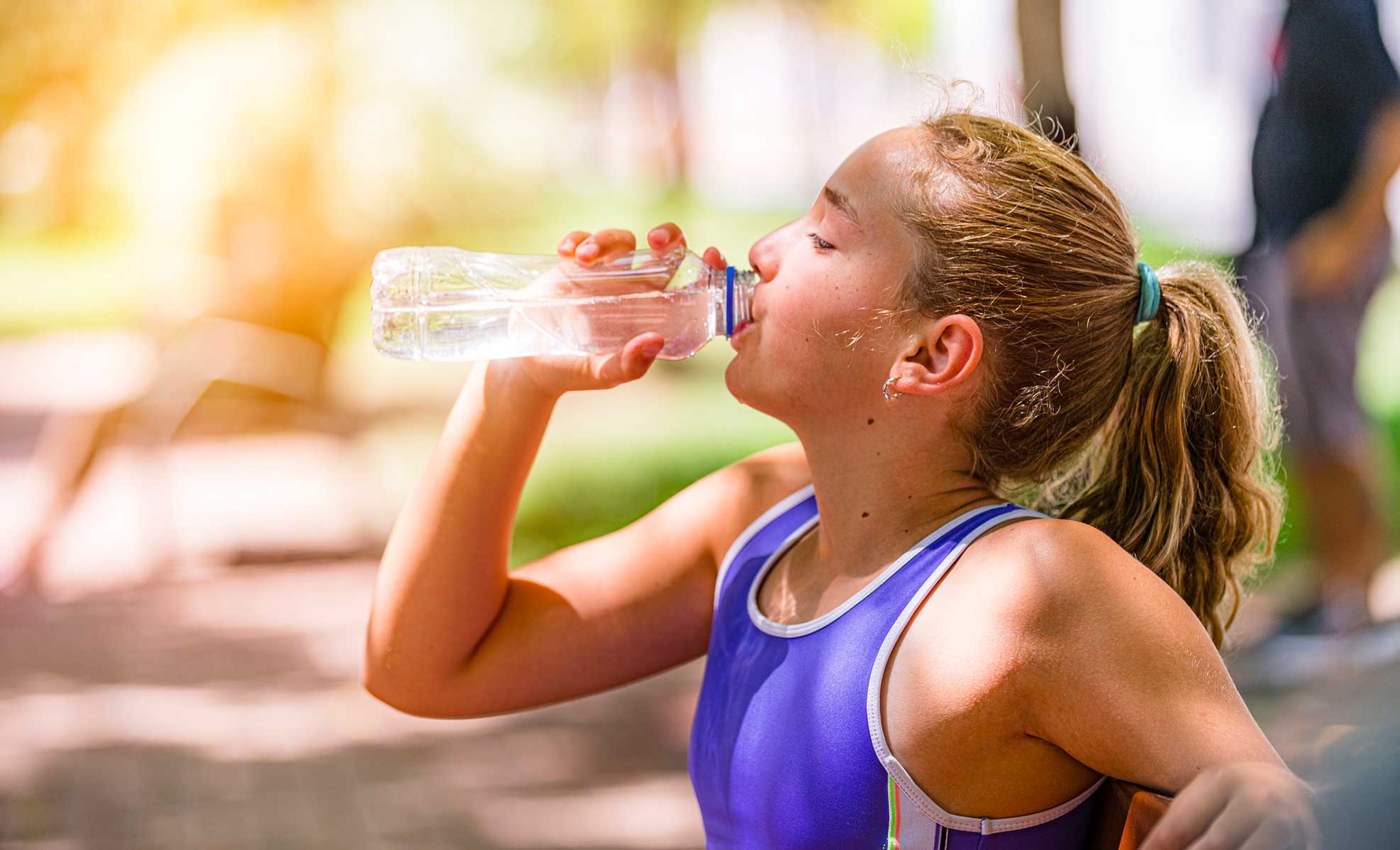 teenage girl drinking water before starting a workout
