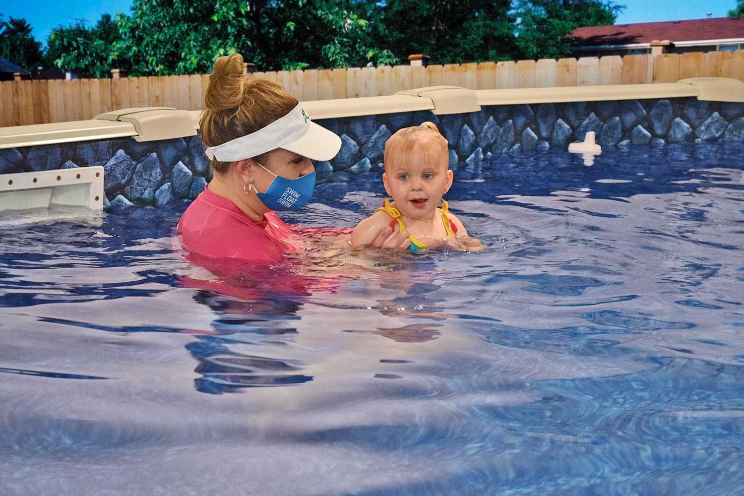 child and swimming instructor during a lessoon