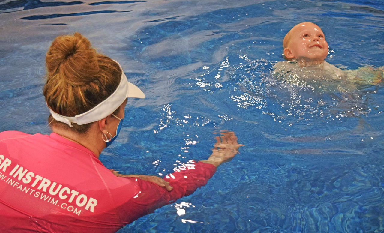 swimming instructor and child in a pool