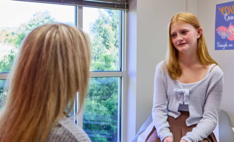 teenage girl talking to her pediatrician during an appointment