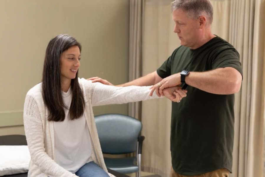 Physical therapist helping a patient with arm mobility