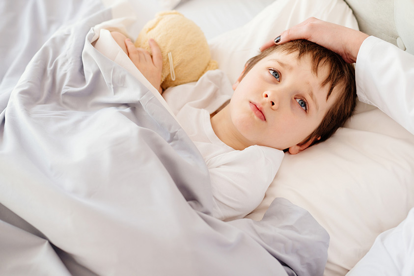 child in bed with a sore throat
