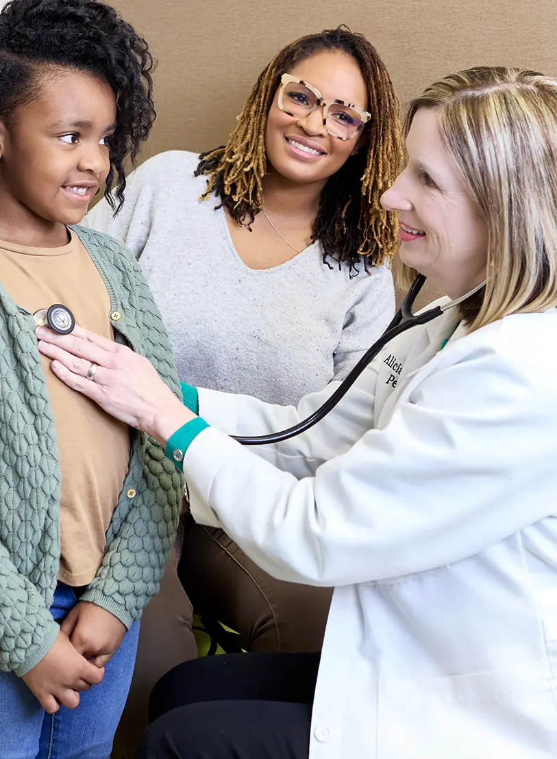 Dr. Wright and pediatric patient with mom during a checkup