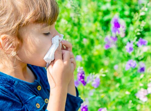 woman holding her head, suffering from allergies