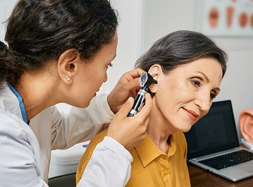 ENT specialist checking on a patient's ear