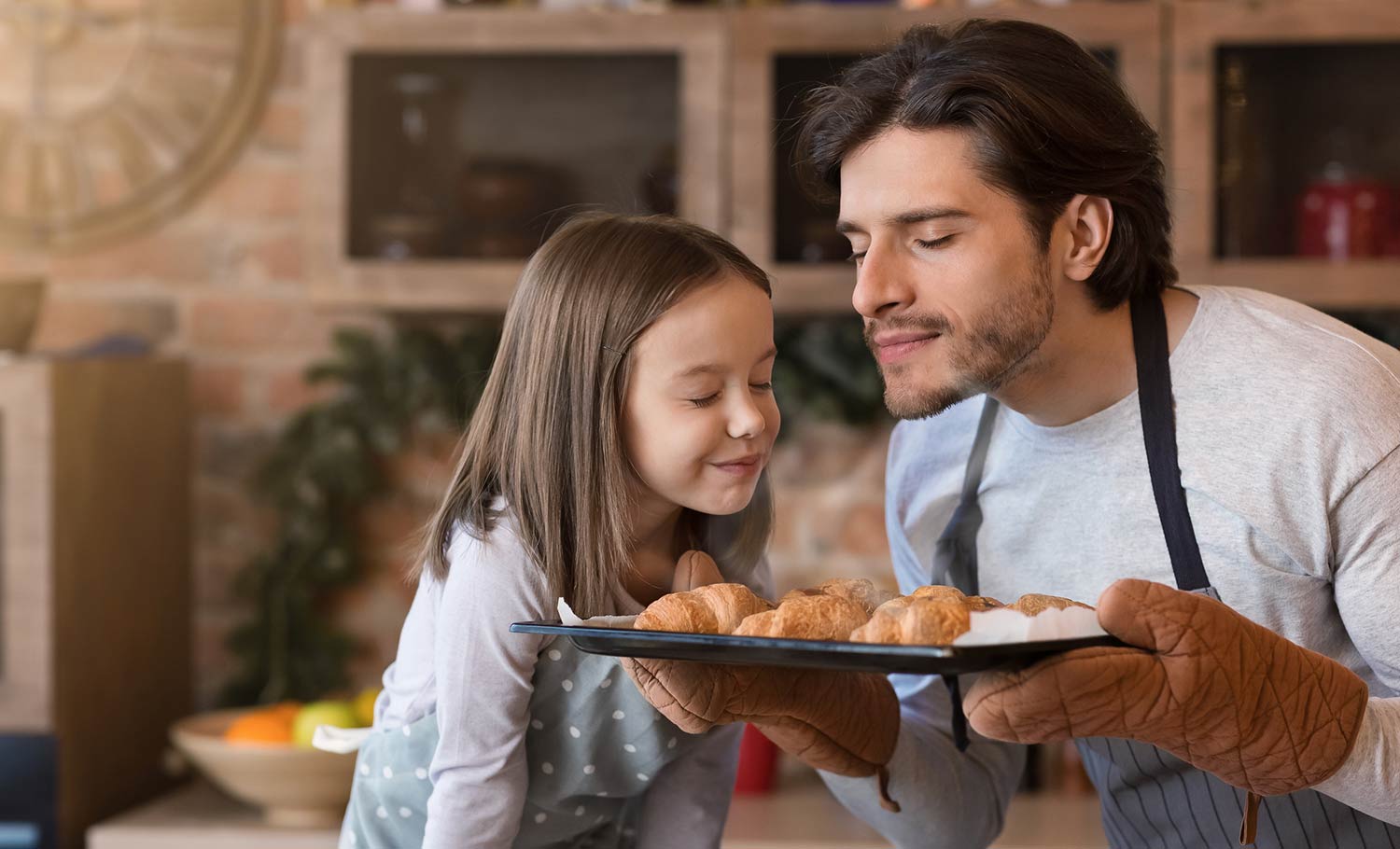 father and daughter smelling baked bread